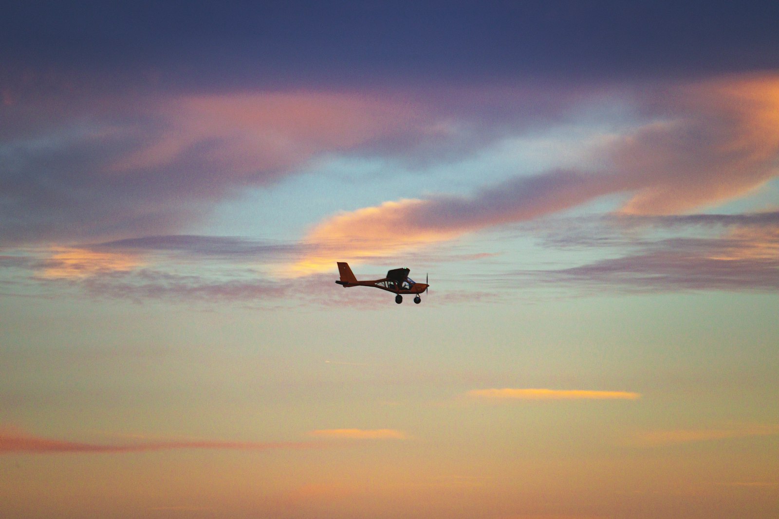 Kleines Flugzeug fliegt durch einen wolkigen Himmel